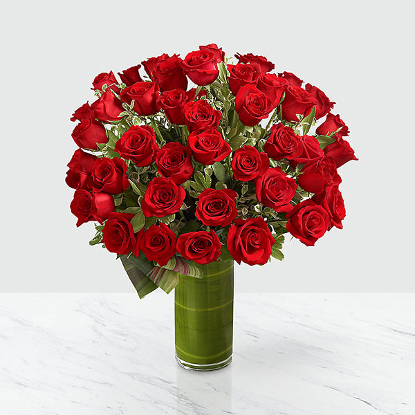  A gorgeous and lush bouquet of 24-inch premium long-stemmed red roses, beautifully situated in a superior 10-inch clear glass cylindrical vase, are the perfect way to shine a light on your every emotion. 24-inch premium long-stemmed red roses, assorted greens, exotic foliage and a 10-inch superior clear glass cylinder vase.
