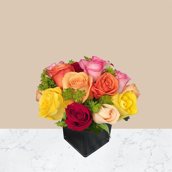 one dozen mixed colored roses in a short square vase