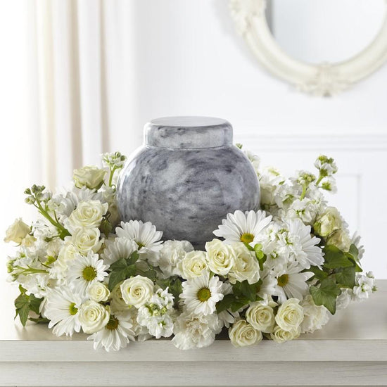 Perfect for displaying an urn or framed photograph during a service in the center of a ring of florals, this arrangement is crafted with stock, spray roses and more. 