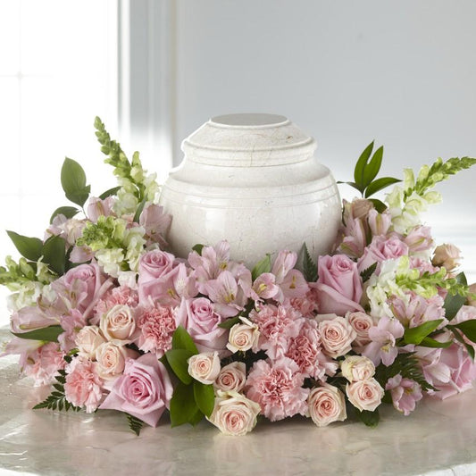 pink and white blooms including roses, alstroemeria, snapdragons and carnations.  Adornment is approximately 11"H x 23"W  ***Urn shown is not included.***