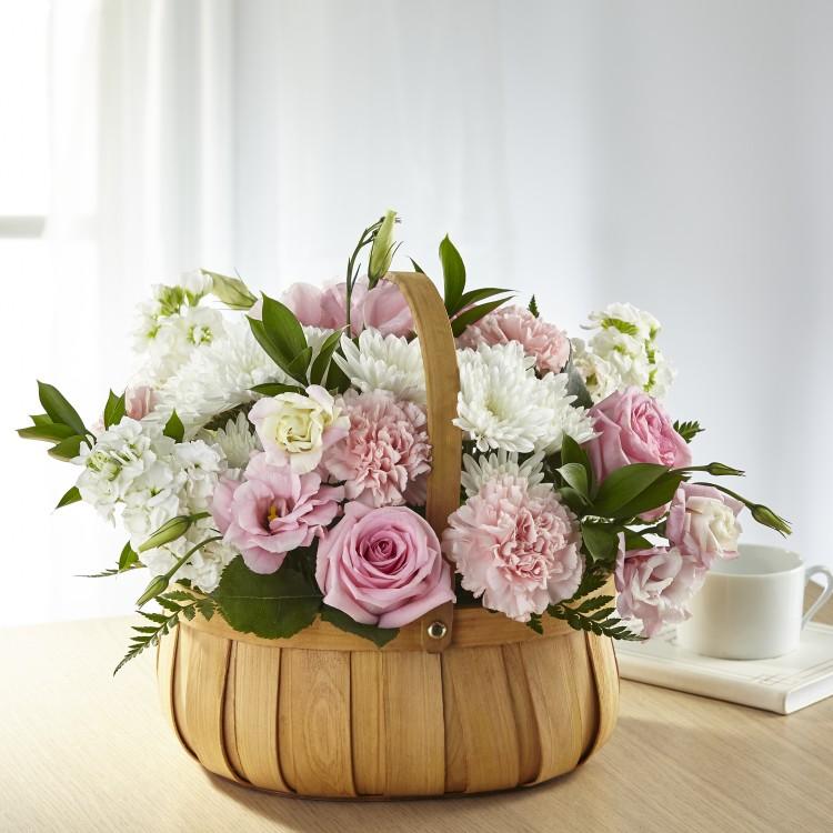 pink and white blooms of roses, lisianthus, stock, carnations, and chrysanthemum in a basket