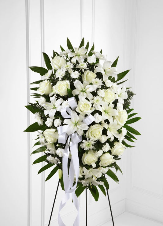 Elegantly crafted with roses, lilies, mini carnations and accented with palm fronds.