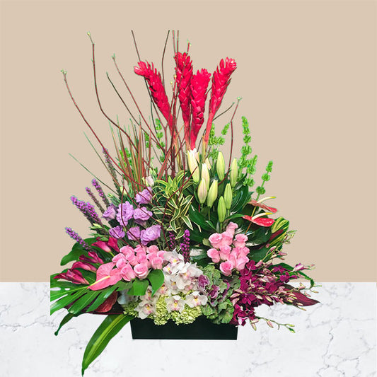 A striking array of bold and exotic colors tie together this show stopping tropical spring arrangement.