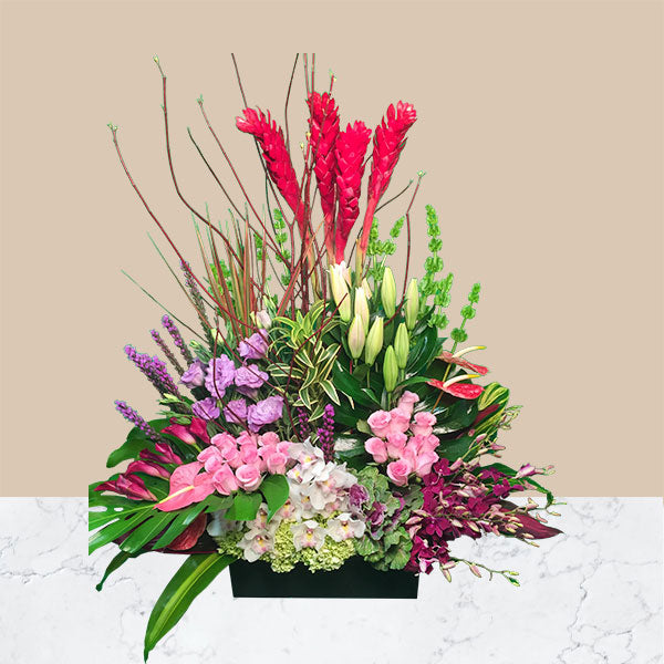 A striking array of bold and exotic colors tie together this show stopping tropical spring arrangement.